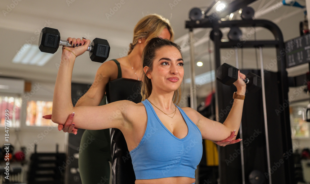Personal trainer guiding client through corrective exercises in a bright studio